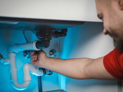 Plumber inspecting under sink
